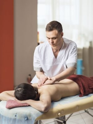 A young specialist performs a general massage for his client in the office